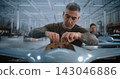 Male Factory Worker Mounting Electronic Circuit Board During Drone Assembly 143046886