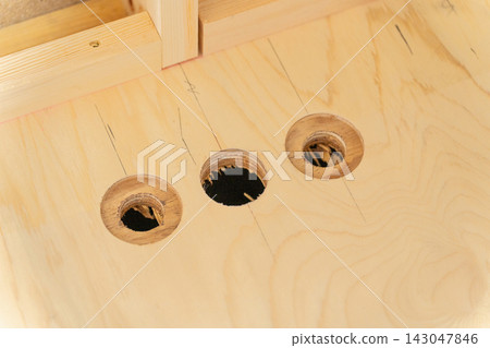 一座新建木屋的建築工地。膠合板上鑽有管道通孔,房屋正在建造中。 一座新建木屋的建築工地。膠合板上鑽有管道通孔,房屋正在建造中。 143047846