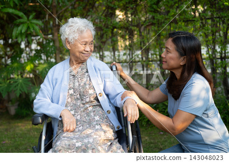 Caregiver help and care Asian senior woman patient sitting on wheelchair at park. Caregiver help and care Asian senior woman patient sitting on wheelchair at park. 143048023