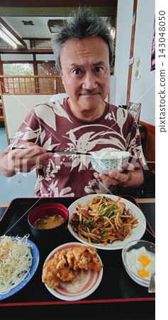 一名男子在中餐館吃一份肝蔥炒套餐。 一名男子在中餐館吃一份肝蔥炒套餐。 143048050