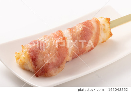 Fish cake wrapped in bacon on a skewer Fish cake wrapped in bacon on a skewer 143048262