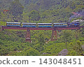 A steam locomotive on the Nilgiri Mountain Railway travels through tea plantations. 143048451