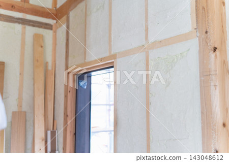 Spray foam insulation for a newly built wooden house. The interior walls and window frames are insulated with polyurethane foam. Spray foam insulation for a newly built wooden house. The interior walls and window frames are insulated with polyurethane foam. 143048612