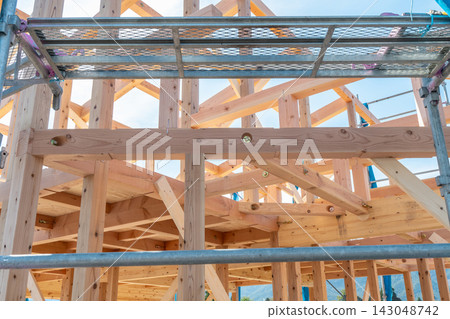 一處木屋建築工地。鷹架環繞,一棟新建的獨立式房屋正在進行框架搭建和施工。 一處木屋建築工地。鷹架環繞,一棟新建的獨立式房屋正在進行框架搭建和施工。 143048742