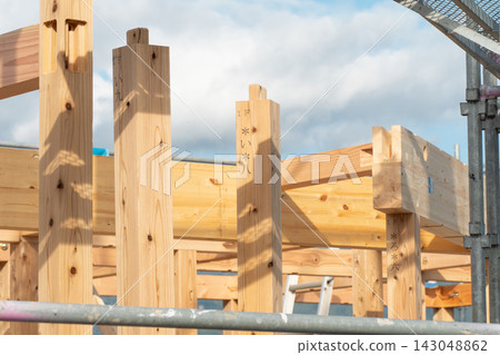 這是一個正在建造新木屋的建築工地。屋頂框架完成後,房屋的框架結構清晰可見,立柱和橫樑都已豎立起來。 這是一個正在建造新木屋的建築工地。屋頂框架完成後,房屋的框架結構清晰可見,立柱和橫樑都已豎立起來。 143048862