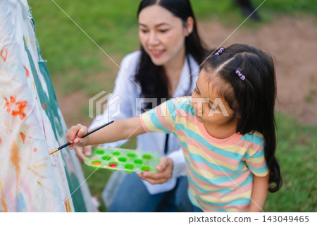 mother and preschool child girl painting watercolors on canvas outdoors in park mother and preschool child girl painting watercolors on canvas outdoors in park 143049465