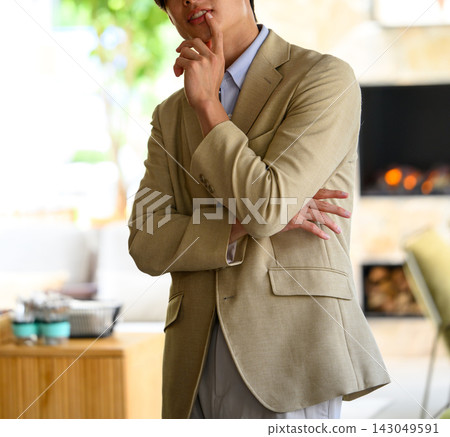 一位沉思的男士在壁爐前將手指放在嘴唇上。 一位沉思的男士在壁爐前將手指放在嘴唇上。 143049591