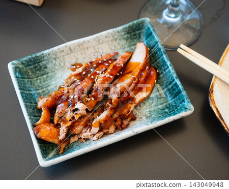 Appetizing pieces of baked duck breast are served with spicy sauce and decorated with white sesame seeds Appetizing pieces of baked duck breast are served with spicy sauce and decorated with white sesame seeds 143049948