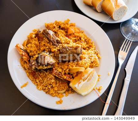 Seafood and meat paella served with fresh lemon Seafood and meat paella served with fresh lemon 143049949