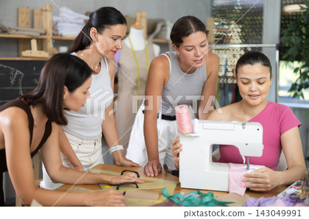 Middle-aged Asian woman showing how to sew Middle-aged Asian woman showing how to sew 143049991
