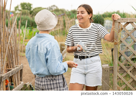 young and mature females, talking at garden young and mature females, talking at garden 143050026