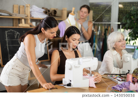 Young woman working at machine during group sewing course 143050038