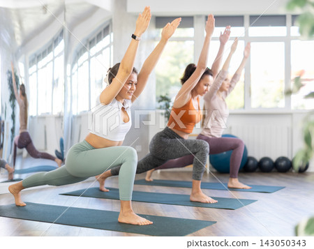 Young woman standing in Ashta Chandrasana balancing asana at yoga training Young woman standing in Ashta Chandrasana balancing asana at yoga training 143050343