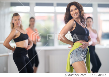 During lesson, woman learn to move and perform dance in heels with women companions During lesson, woman learn to move and perform dance in heels with women companions 143050464