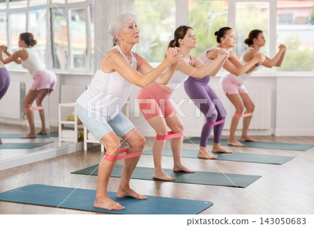 Elderly woman exercises with pilates band Elderly woman exercises with pilates band 143050683