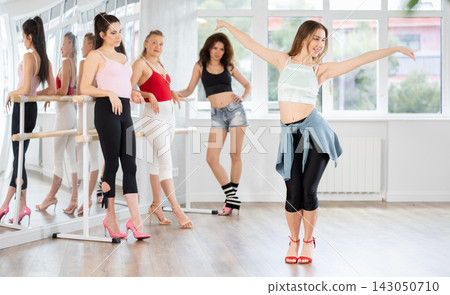 Woman demonstrating movements of vogue dance during group class in studio Woman demonstrating movements of vogue dance during group class in studio 143050710