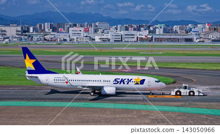 一架 SkyMark 波音 737-800 客機正被拖車拖曳。 一架 SkyMark 波音 737-800 客機正被拖車拖曳。 143050966