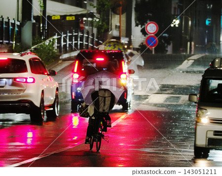 People riding bicycles in the rain People riding bicycles in the rain 143051211