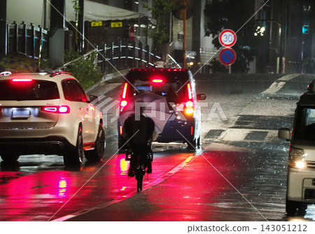People riding bicycles in the rain People riding bicycles in the rain 143051212