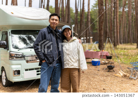 一對情侶依偎在露營車前。 143051367