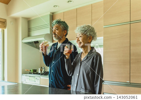 一對情侶在廚房裡喝飲料。 一對情侶在廚房裡喝飲料。 143052061