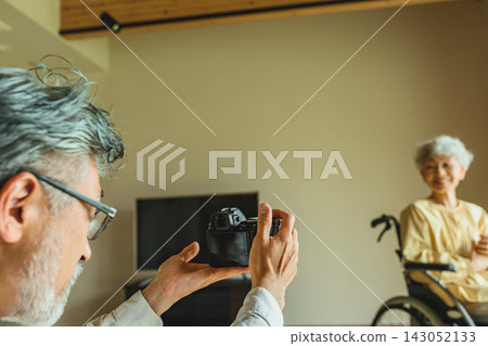 A man photographs a woman in a wheelchair. A man photographs a woman in a wheelchair. 143052133