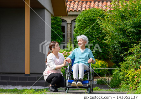 A grandmother in a wheelchair and her caregiver A grandmother in a wheelchair and her caregiver 143052137