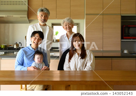A family photo of multiple generations relaxing in the kitchen. A family photo of multiple generations relaxing in the kitchen. 143052143