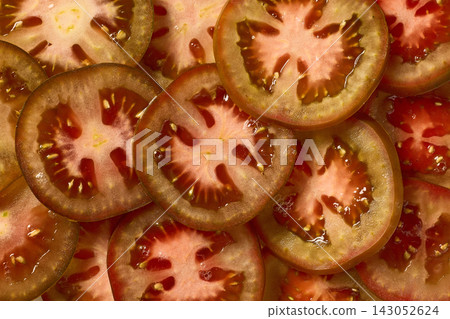Fresh Green Brown Tomato Sliced into Juicy Pieces, Full Frame Macro Top View Fresh Green Brown Tomato Sliced into Juicy Pieces, Full Frame Macro Top View 143052624