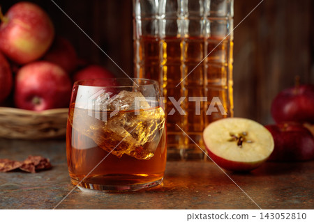 Apple cocktail with ice on a brown background. Apple cocktail with ice on a brown background. 143052810