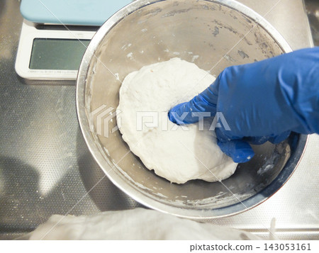 Ingredients for rice flour bread in a bowl and blue gloves Ingredients for rice flour bread in a bowl and blue gloves 143053161