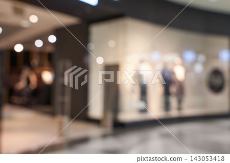 Blurred Retail Storefront Interior With Mannequins And Ambient Bokeh Lighting In Shopping Corridor Blurred Retail Storefront Interior With Mannequins And Ambient Bokeh Lighting In Shopping Corridor 143053418