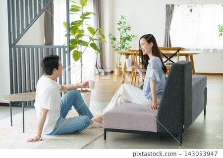 一對年輕的日本明星夫婦坐在客廳裡聊天。 一對年輕的日本明星夫婦坐在客廳裡聊天。 143053947