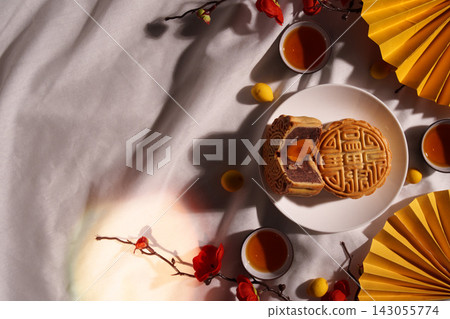 Mid-Autumn Festival concept with traditional mooncakes and tea on white silk Mid-Autumn Festival concept with traditional mooncakes and tea on white silk 143055774