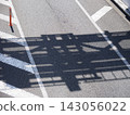 A quiet daytime view of the road surface from a pedestrian overpass. 143056022