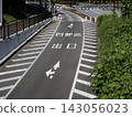 A quiet daytime view of the road surface from a pedestrian overpass. 143056023