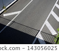 A quiet daytime view of the road surface from a pedestrian overpass. 143056025