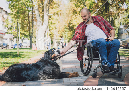 Happy young man with a physical disability in a wheelchair with his dog. Happy young man with a physical disability in a wheelchair with his dog. 143056267