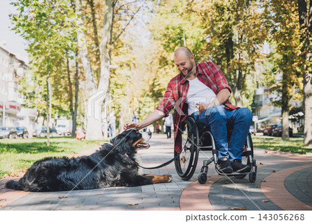 Happy young man with a physical disability in a wheelchair with his dog. Happy young man with a physical disability in a wheelchair with his dog. 143056268