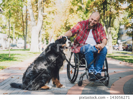 Happy young man with a physical disability in a wheelchair with his dog. Happy young man with a physical disability in a wheelchair with his dog. 143056271