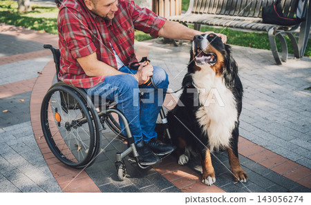 Happy young man with a physical disability in a wheelchair with his dog. Happy young man with a physical disability in a wheelchair with his dog. 143056274