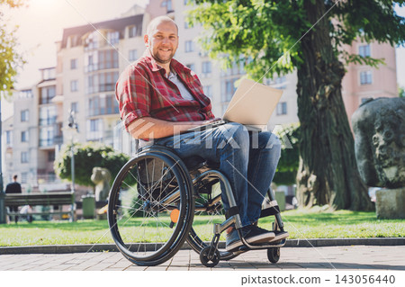Freelancer with a physical disability in a wheelchair working at the park Freelancer with a physical disability in a wheelchair working at the park 143056440