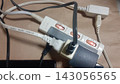 Image of a complex wiring setup with multiple power strips and their cords concentrated in one area. 143056565