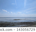 A calming scene of a tidal flat coastline under a blue sky. 143056729