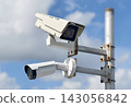 Cluster of outdoor security cameras mounted on metal pole watching property 143056842