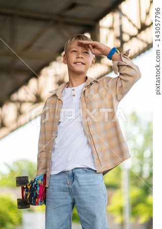 Fair-haired boy of school age with a skateboard looking confident 143057796