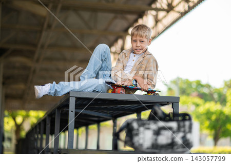 Young skateboarder resting after a skateboard ride and looking relaxed 143057799