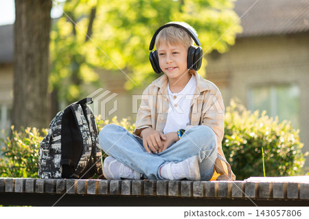 Cute blonde teen sitting in the headphones and enjoying the music Cute blonde teen sitting in the headphones and enjoying the music 143057806