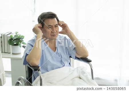Senior man in his wheelchair having a headache at hospital. Senior man in his wheelchair having a headache at hospital. 143058065