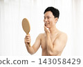 A man looks in the mirror after getting his beard removed. 143058429